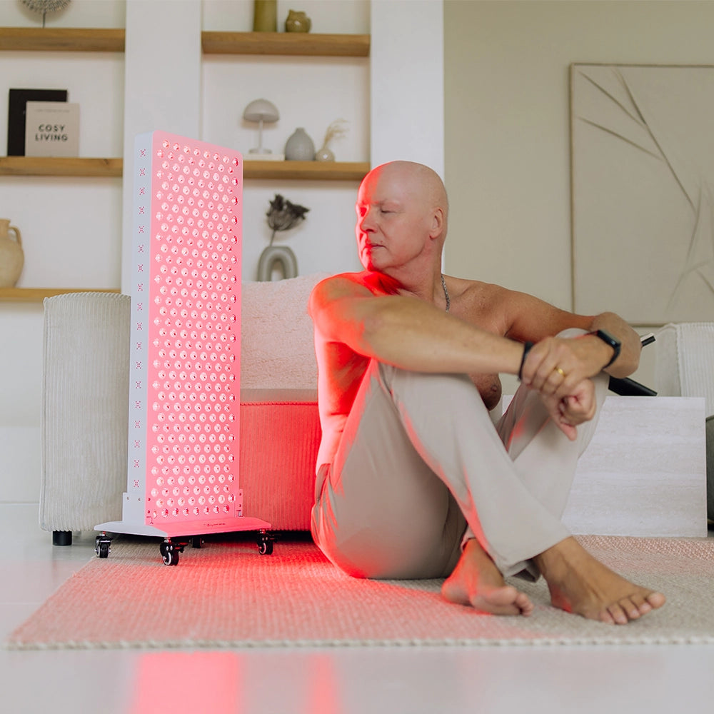 Man behandelt zijn rug met de Liroma Elite rood licht therapie lamp